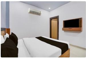um quarto com uma cama e uma TV na parede em Collection O High Court Lucknow em Vibhuti Khand