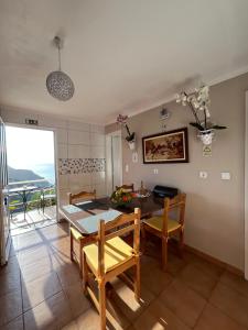 a dining room with a table and chairs and a balcony at Tropical House in Ribeira Brava