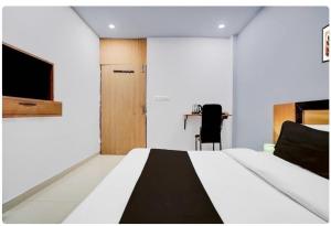 um quarto com uma cama grande e uma escrivaninha em Collection O High Court Lucknow em Vibhuti Khand