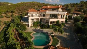 an aerial view of a house with a swimming pool at Ourdreamhouses Lake Hereou Loutraki in Vouliagmeni Lake