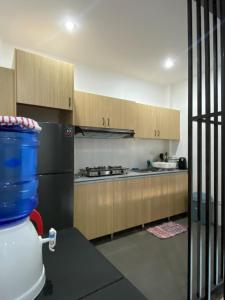 cocina con armarios de madera y fogones en Villa Talisay Ocean View, en Samal 24 fotos más