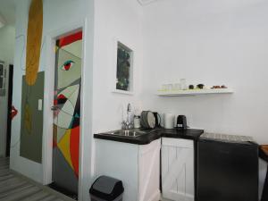 a kitchen with a sink and a painting on the wall at Manello Home Art in Athens +22 photos