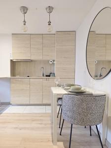 Un comedor con una mesa y un espejo. en memore, en Mons