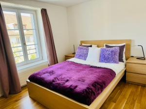 a bedroom with a purple bed with a window at Gasthaus Hirschen Mandach by perfect lifestyle in Böttstein