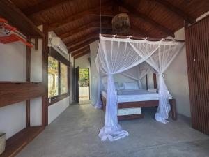 un dormitorio con una cama con mosquitera en Índico Breeze, en Praia do Tofo
