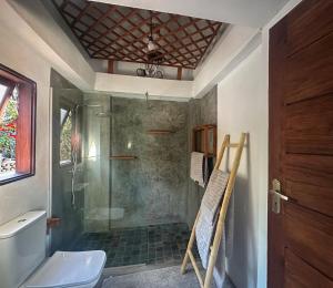 Un baño con ducha, inodoro y lavabo. en Índico Breeze, en Praia do Tofo