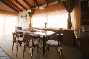 a kitchen with a table and chairs in a room at Ourdreamhouses Lake Hereou Loutraki in Vouliagmeni Lake