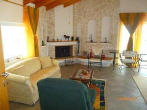 a living room with a couch and a fireplace at Ourdreamhouses Lake Hereou Loutraki in Vouliagmeni Lake