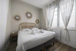een slaapkamer met een bed met witte lakens en een raam bij Appartement cozy au centre-ville in Brest