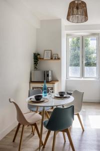 een eetkamer met een tafel en stoelen bij Appartement cozy au centre-ville in Brest