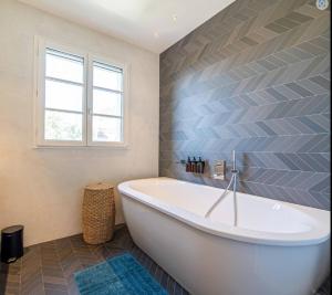 eine weiße Badewanne im Bad mit Fenster in der Unterkunft Villa Violette in Tourrettes-sur-Loup + 9 Fotos