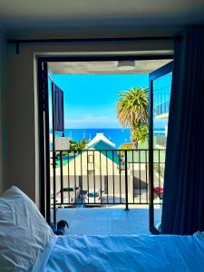 1 dormitorio con vistas al océano desde el balcón en Marina Views Simon's Town, en Simonʼs Town