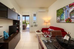 a living room with a red couch and wine glasses at Levanta Cozy Apartment #1 in Kalavarda Rhodes in Kalavárda