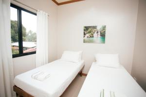 deux lits dans une chambre avec une fenêtre dans l'établissement RGE Hotel, à Belen 50 autres photos