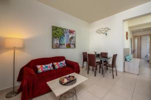 a living room with a red couch and a table at Levanta Cozy Apartment #1 in Kalavarda Rhodes in Kalavárda