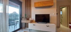 a living room with a flat screen tv on a dresser at Matin's cozy nest in Tríkala