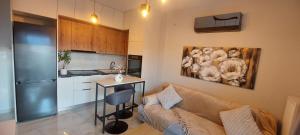 a living room with a couch and a kitchen at Matin's cozy nest in Tríkala