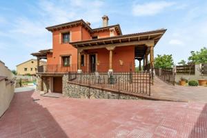 a large orange house with a balcony on a brick driveway at Casa Rural Los Hebrero in Torrecaballeros