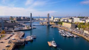 een groep boten aangemeerd in een rivier in een stad bij Appartement cozy au centre-ville in Brest