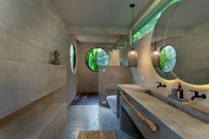a bathroom with a sink and a toilet and two windows at Utopia Concept Bali - Adults Only in Ubud +216 photos