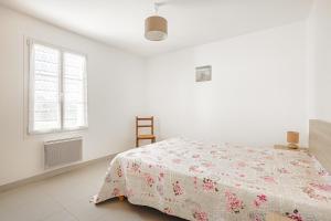 ein weißes Schlafzimmer mit einem Bett und einem Fenster in der Unterkunft Villa Du Chai in Sainte-Marie-de-Ré