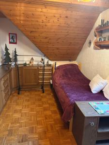 um quarto no sótão com uma cama e uma cozinha em Ferienwohnung Jägerhaus em Walldürn