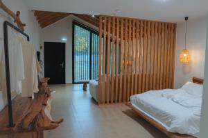 Un dormitorio con una cama y una ventana grande. en λαλώ, en Órma