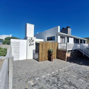 Una casa blanca con un cartel en el costado. en High Level Self Catering, en Agulhas