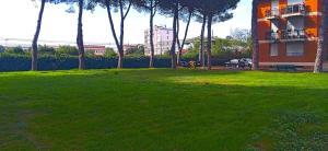 利沃诺Rombolino Guesthouse -Free Parking - Vicino al PalaLivorno "Modigliani Forum"的一个绿树成荫的公园，里面有一栋建筑，还有一栋建筑