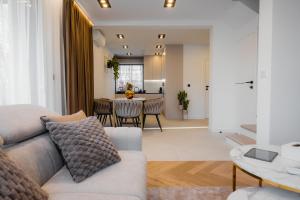 Zamkowy Zakątek - Luksusowe domki z jacuzzi في Nowy Wiśnicz: غرفة معيشة بها أريكة وطاولة