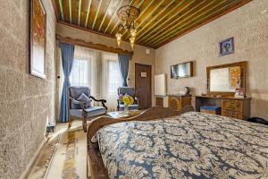 a bedroom with a bed and two chairs in a room at Cappadocia Inn Cave Hotel in Goreme