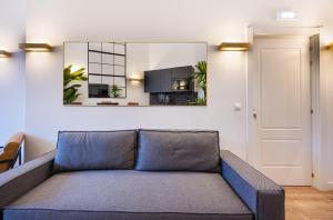 a couch in a living room with a mirror at ºIM La Latina-City Centre-WiFi-AC-SmartTVº in Madrid +3 photos