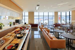 a restaurant with a buffet line with tables and chairs at Candeo Hotels Hiroshima Hatchobori in Hiroshima +6 photos