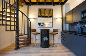 Una barra con dos taburetes y un cubo de basura. en A IM La Latina-City Centre-WiFi-AC-SmartTV A, en Madrid