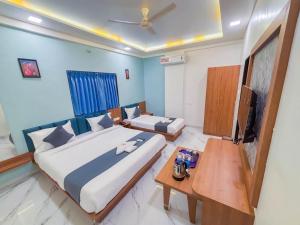 浦那Sunrise Comfort Rooms - International Tech Park Kharadi Highway的一间卧室，里面有两张床和一张桌子