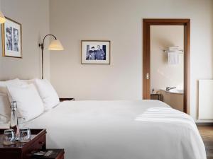 ein Schlafzimmer mit einem großen weißen Bett und ein Badezimmer in der Unterkunft ABION Villa Suites in Berlin + 29 Fotos