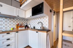 a kitchen with white cabinets and a sink at The cozy corner of Amelie in Nice +11 photos