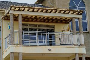 a balcony of a house with blue doors andwindows at Lake Sight Uganda in Kampala