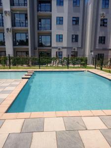 a swimming pool in front of a building at Amos in Gaborone