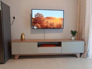 a tv sitting on a wall in a living room at Amos in Gaborone