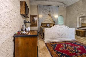 a bedroom with a bed and a dresser in it at Cappadocia Inn Cave Hotel in Goreme