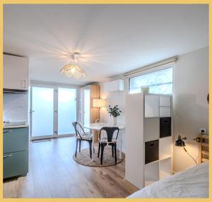 a bedroom with a table and chairs in a room at Chez Mathieu I Studio I Sauverny in Sauverny