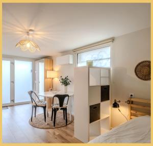 a bedroom with a table and chairs and a bed at Chez Mathieu I Studio I Sauverny in Sauverny +16 photos