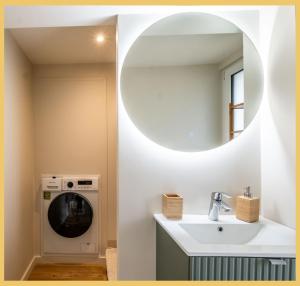 a bathroom with a sink and a washing machine at Chez Mathieu I Studio I Sauverny in Sauverny