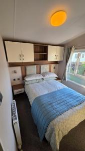 een slaapkamer met een groot bed met een blauwe deken bij Cranfield Bay Getaway in Kilkeel +23 foto's