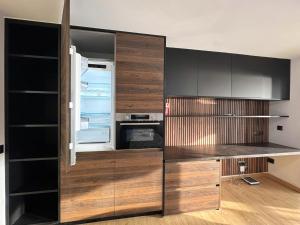 a kitchen with wooden cabinets and an open refrigerator at Albatros 13º in Benidorm