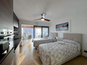 a bedroom with two beds and a ceiling fan at Albatros 13º in Benidorm +22 photos