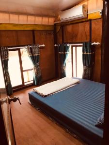 un lit dans une chambre avec des fenêtres sur un bateau dans l'établissement Bee lucky homestay, à Cat Ba