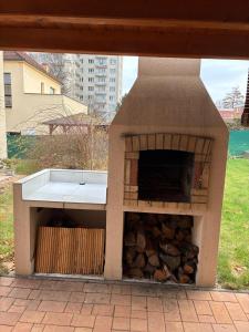 兹林Apartmány Ševcovská的一个带一堆木柴的户外烤箱