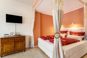 une chambre avec un lit et une télévision au mur dans l'établissement Strandhof Möhnesee, à Wamel